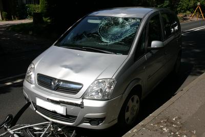 Silver car involved in crash with my bike partially trapped under the bonnet and a shattered windscreen from the impact